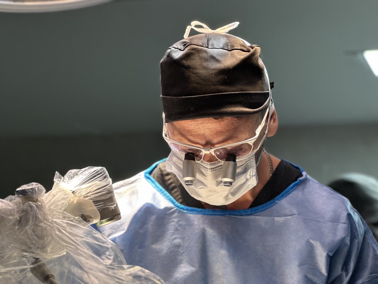 Dr. Lucas Rueda operando con lupas y equipamiento de cirugía